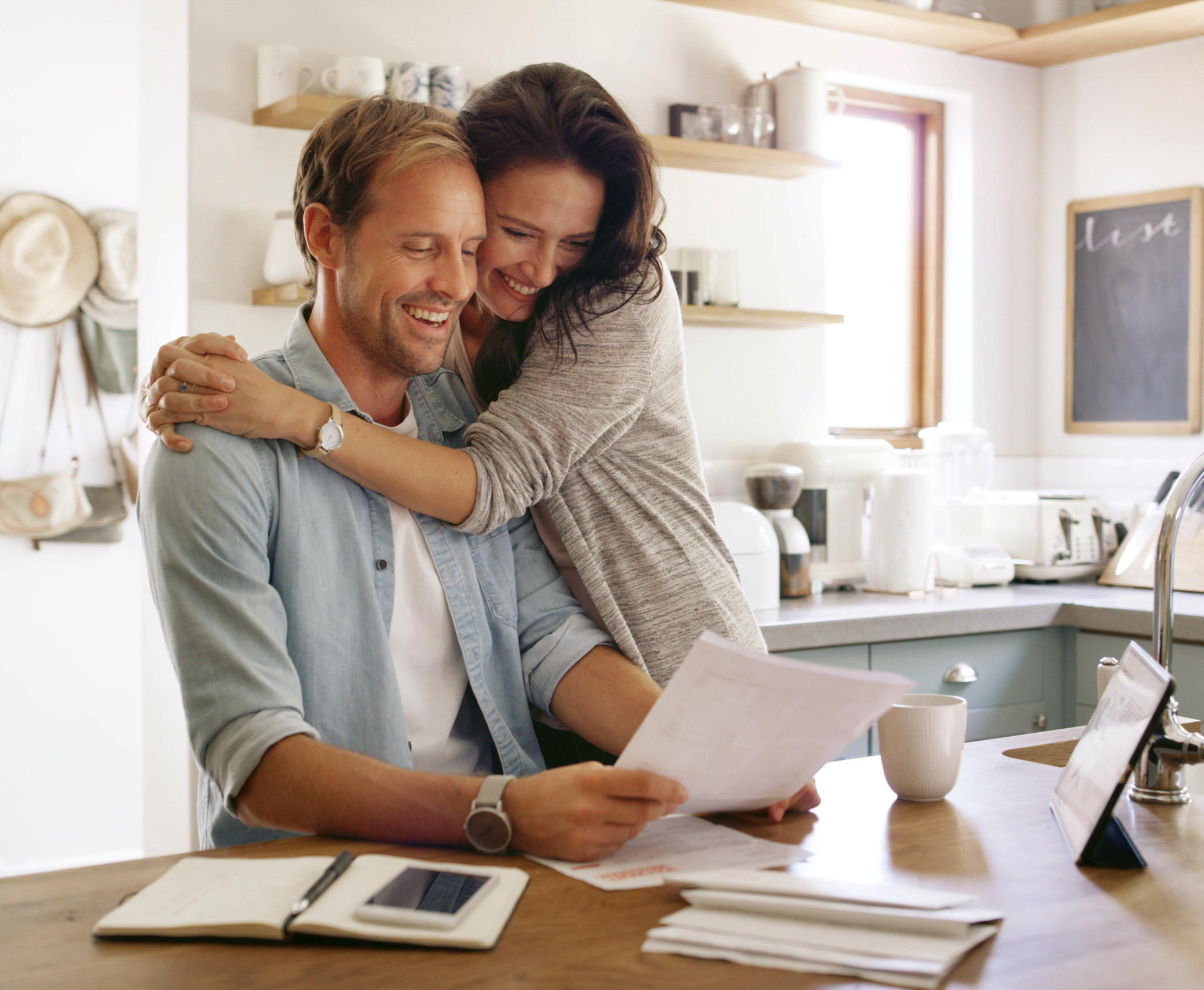 happy couple looking at mortgage paperwork hugging