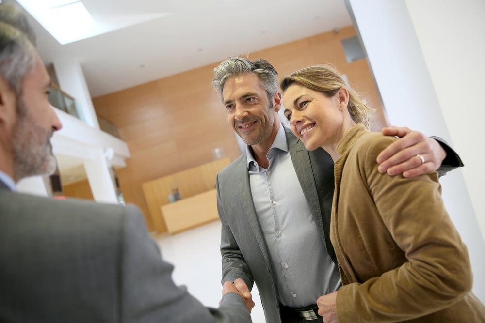 Adviser giving handshake to clients