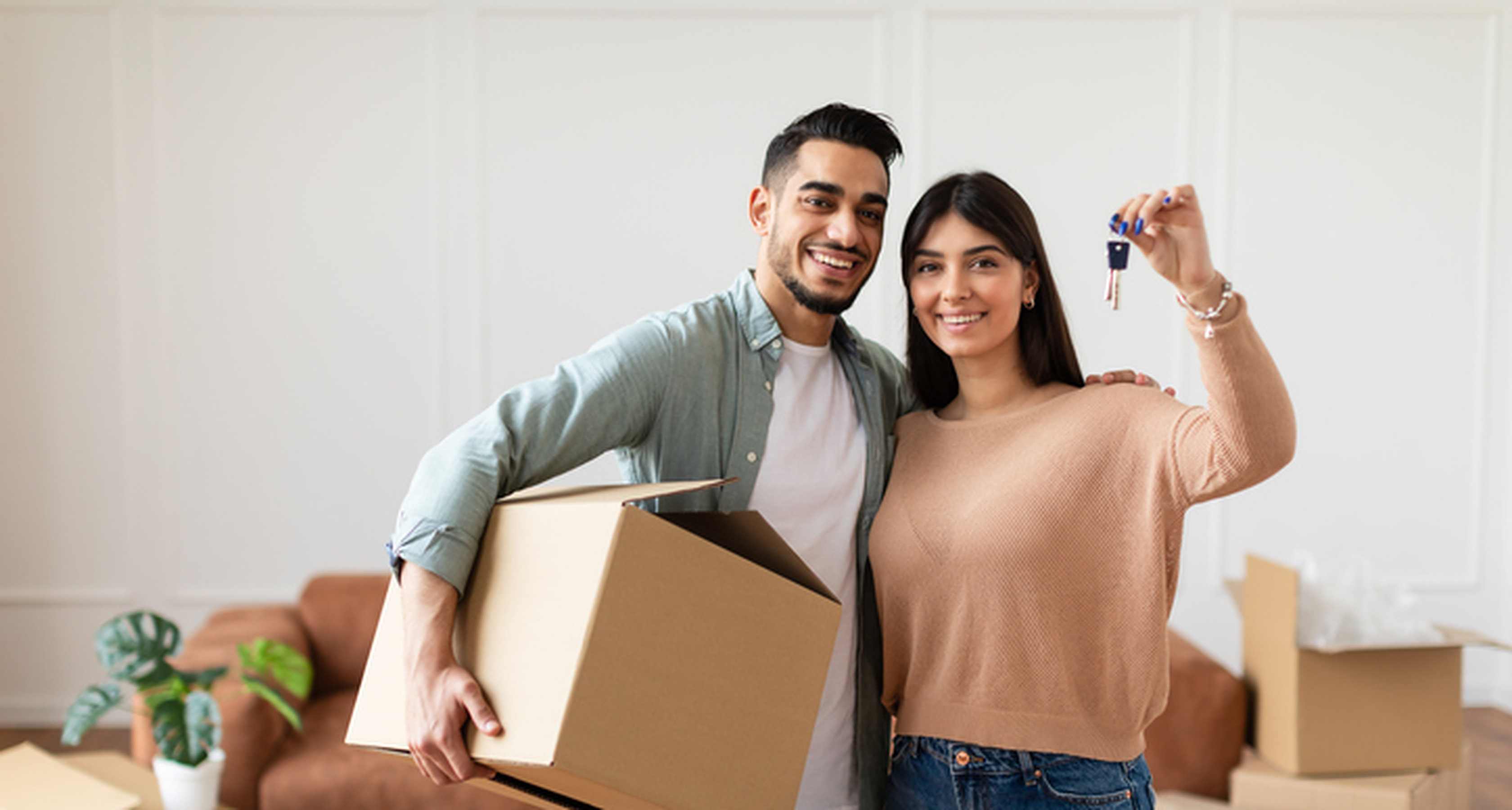 Happy-couple-showing-keys-to-new-apartment