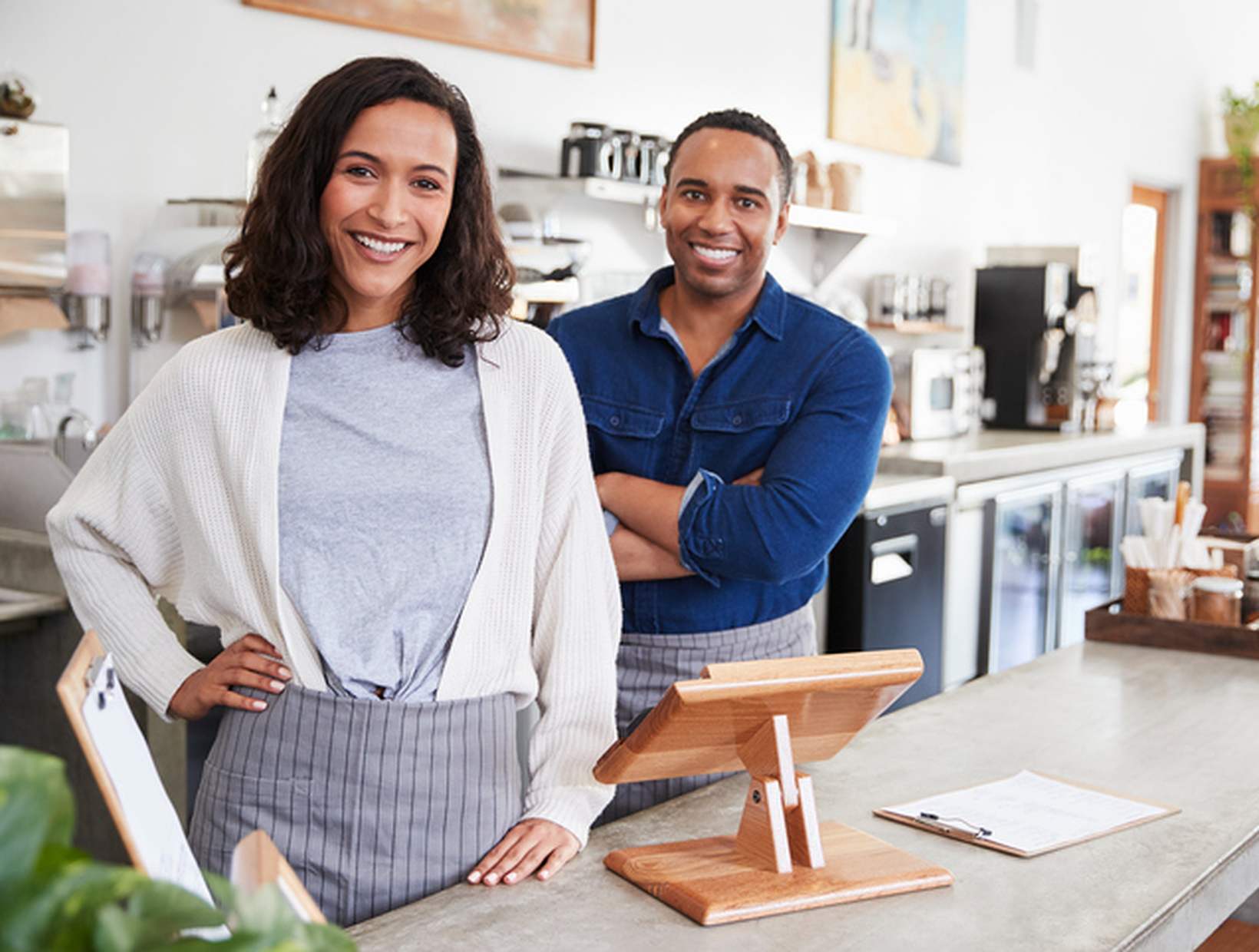 Mixed-race-couple-behind-counter-at-their-coffee-shop