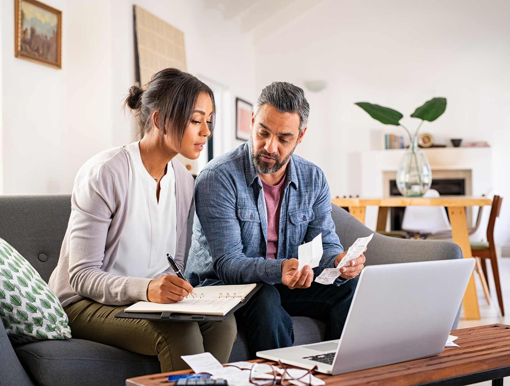 two people filling out papers at home