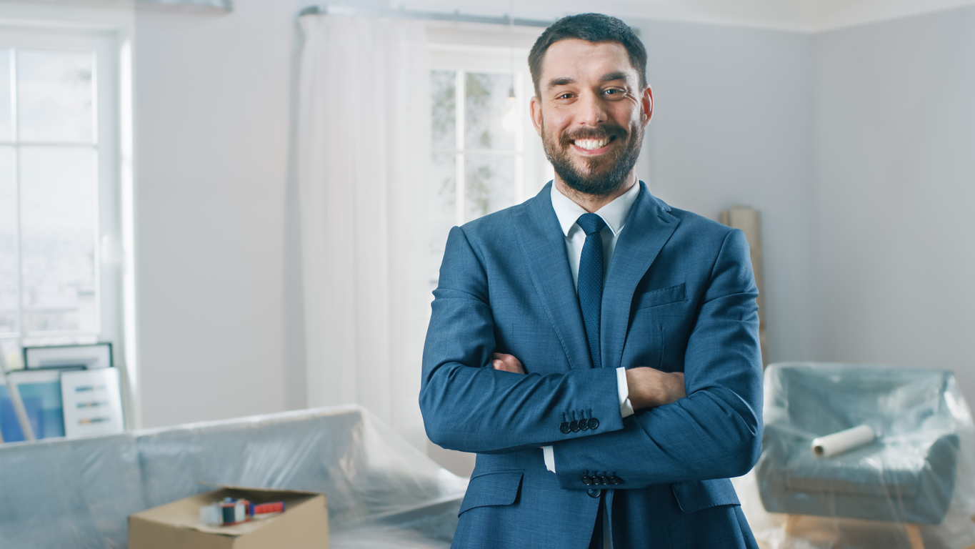 man in business suit smiles in new home