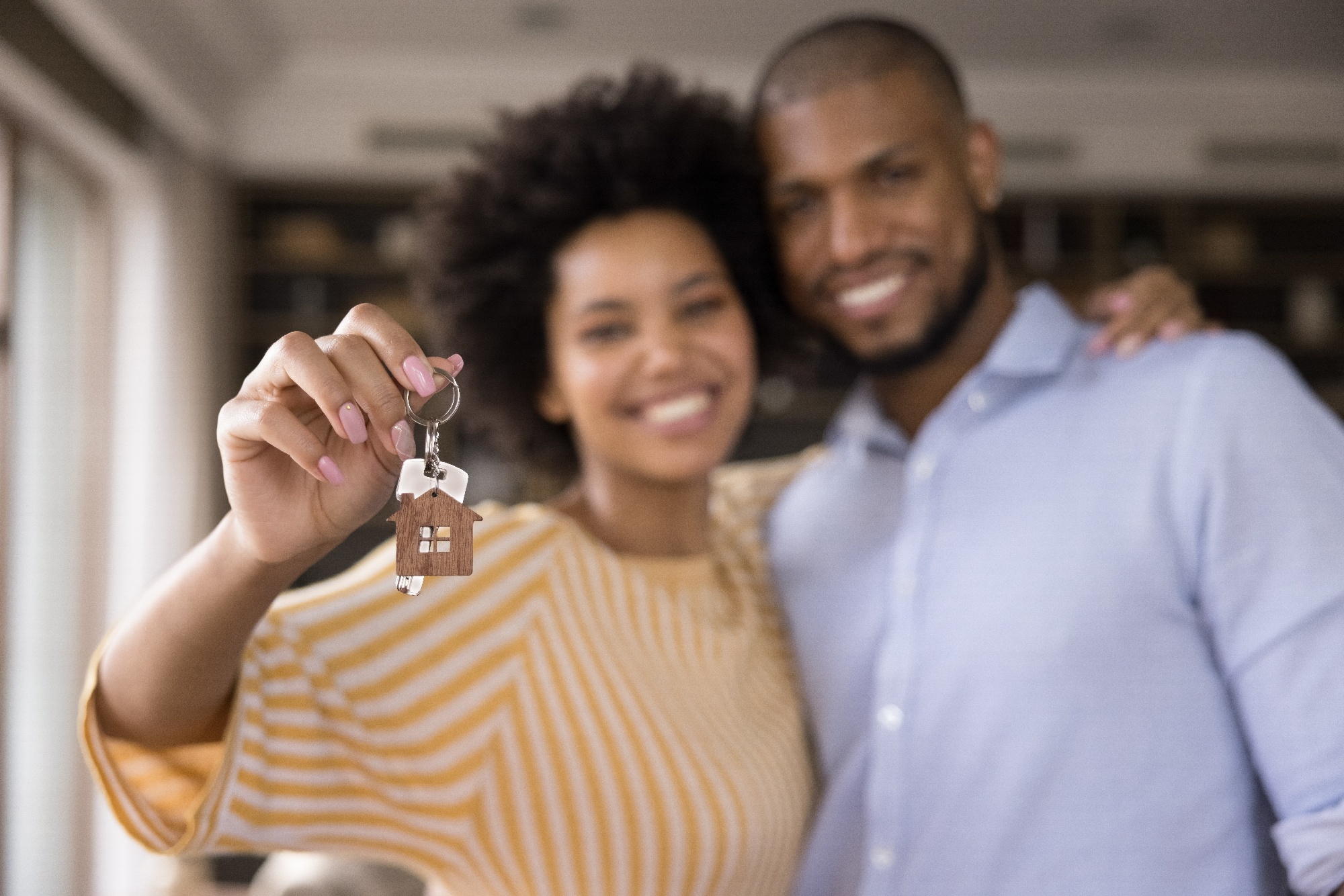 husband and wife holding house keys and smiling