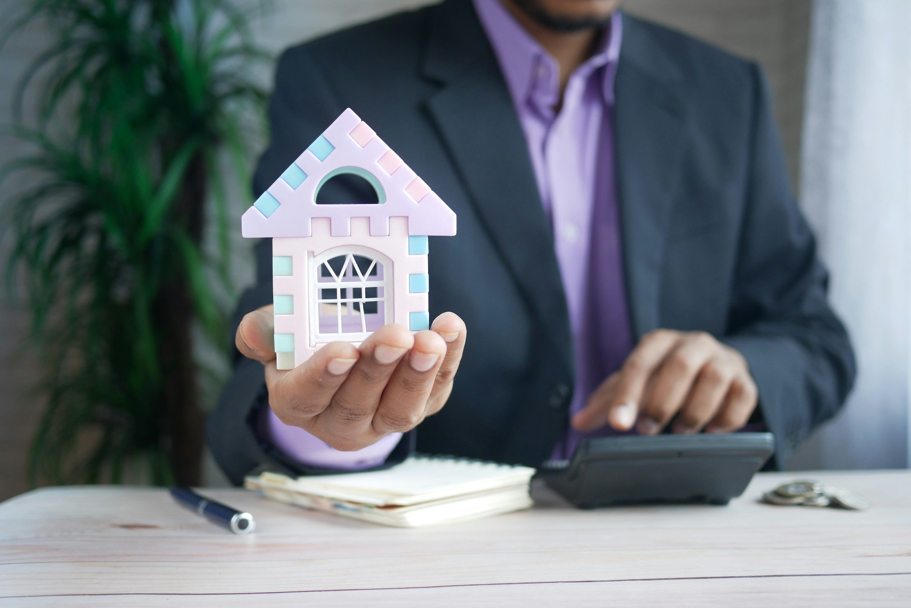 office man holding house figure